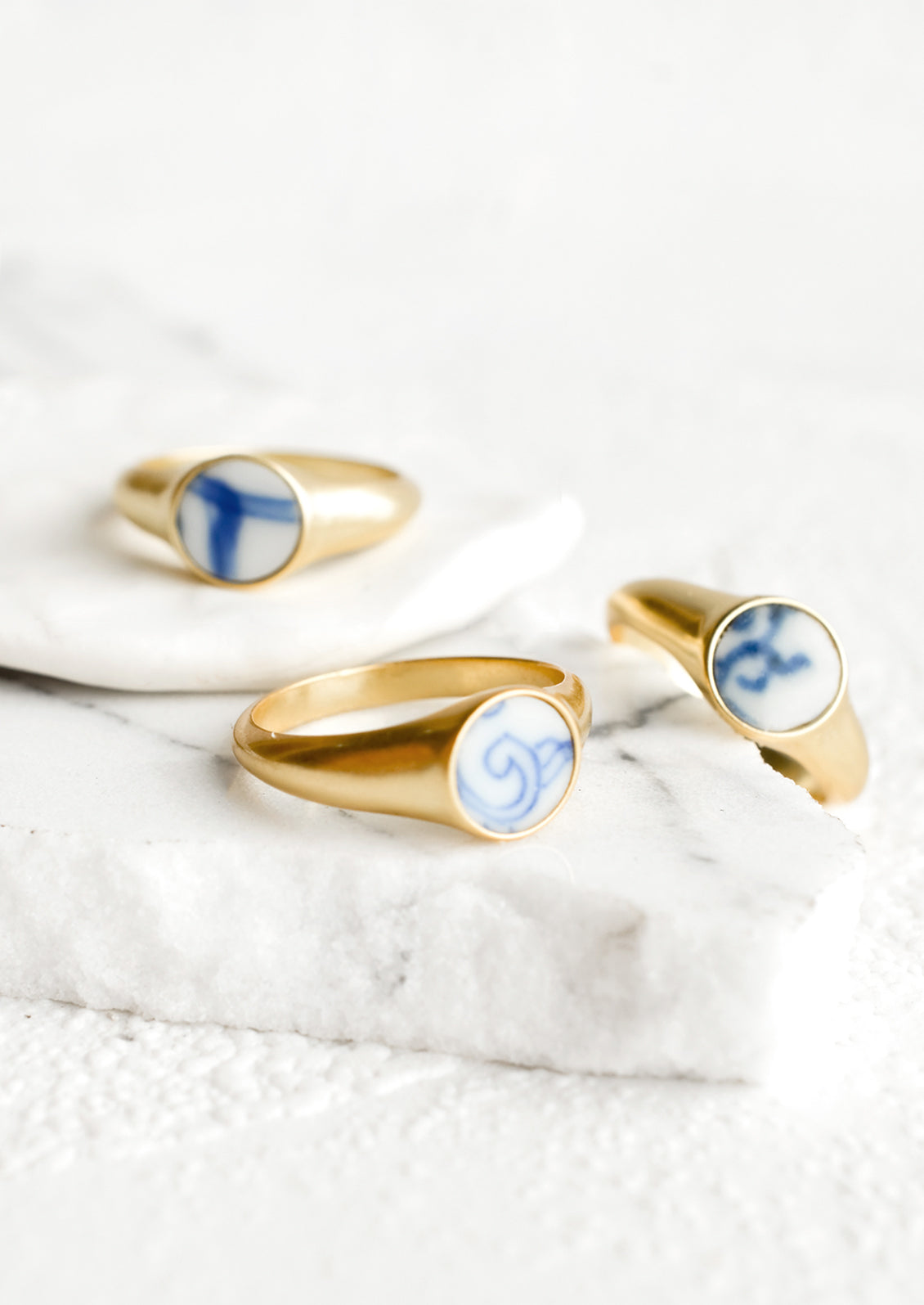 Gold signet rings with blue and white pottery signet.