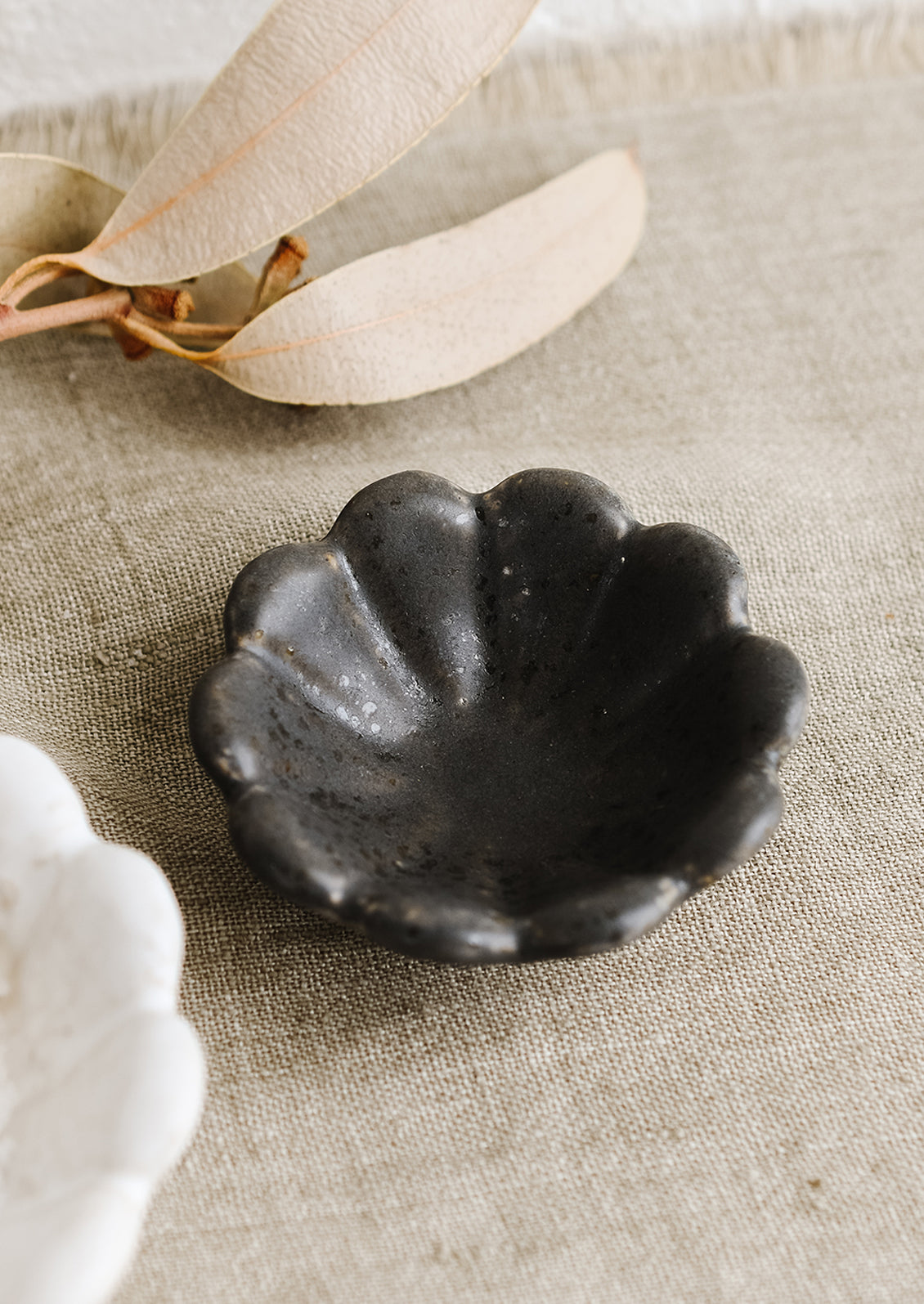 A small black ceramic flower shaped bowl.