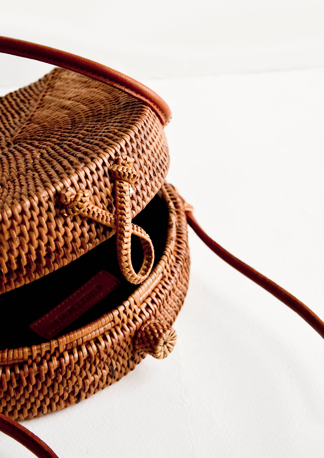 Woven clasp closure on smoked rattan handbag.