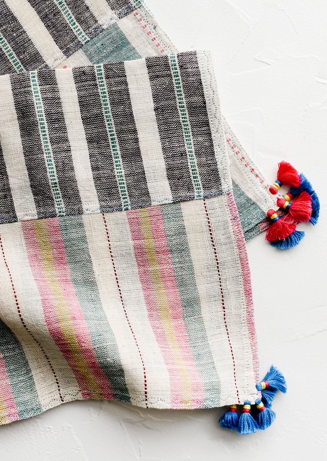 A khadi cotton madras napkin with tassel detailing.