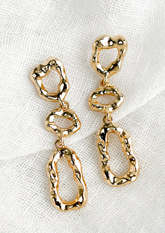 A pair of gold abstract shape drop earrings with melted metal look.