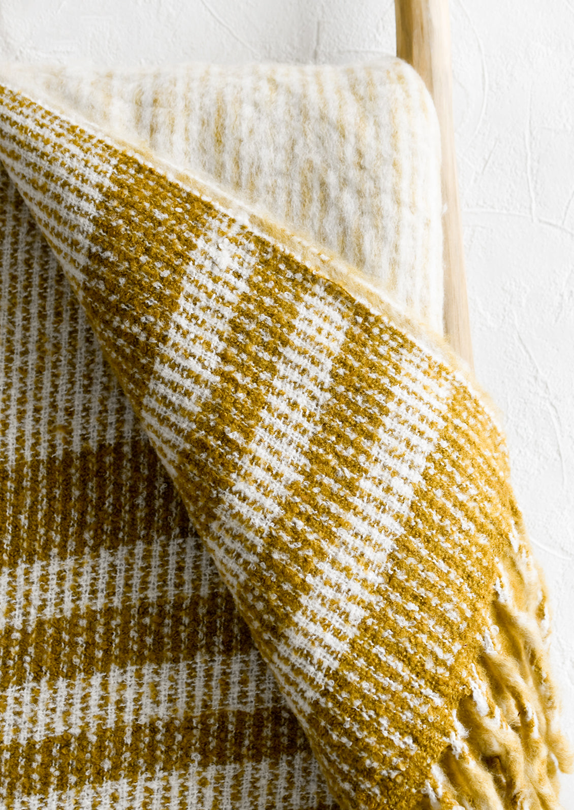 A mohair throw blanket in mustard and ivory stripe.