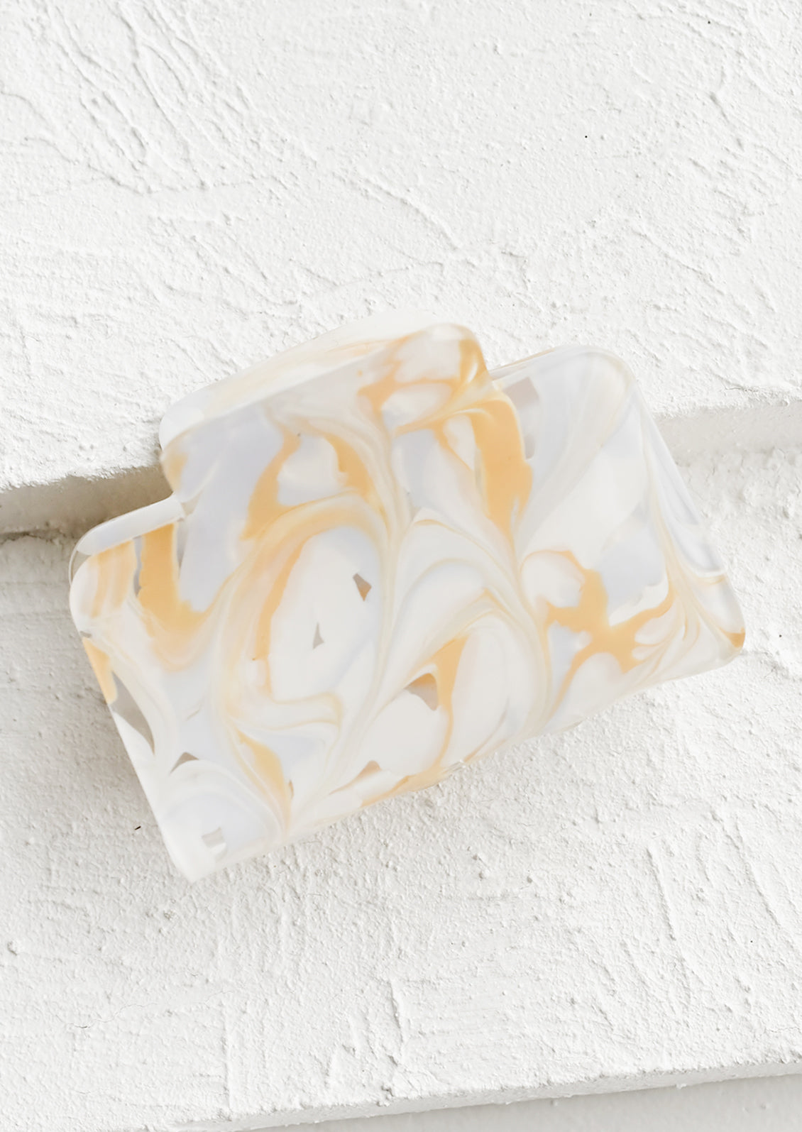 A rectangular acetate hair clip in marbleized white.