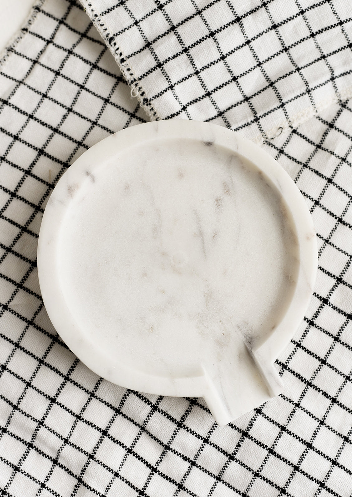 A round white marble spoon rest.