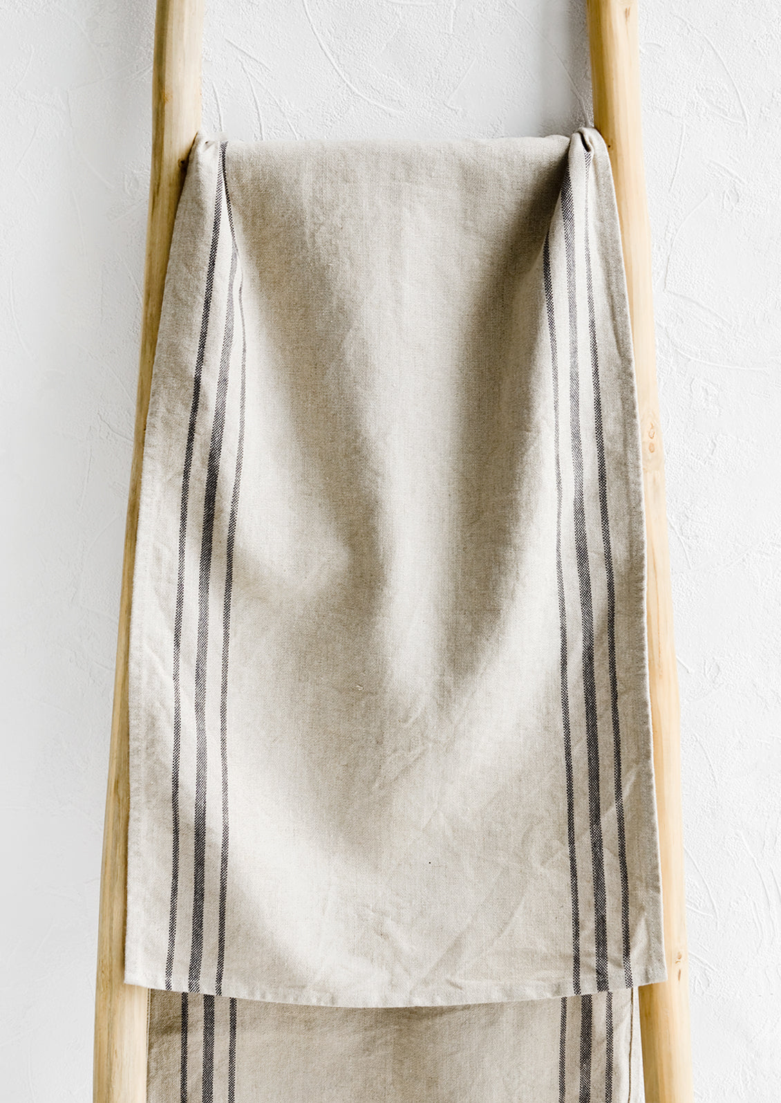 A linen table runner with stripes at sides.
