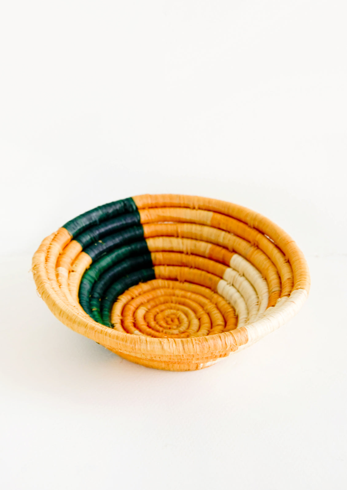 Small raffia bowl in geometric pattern in mustard, green and natural