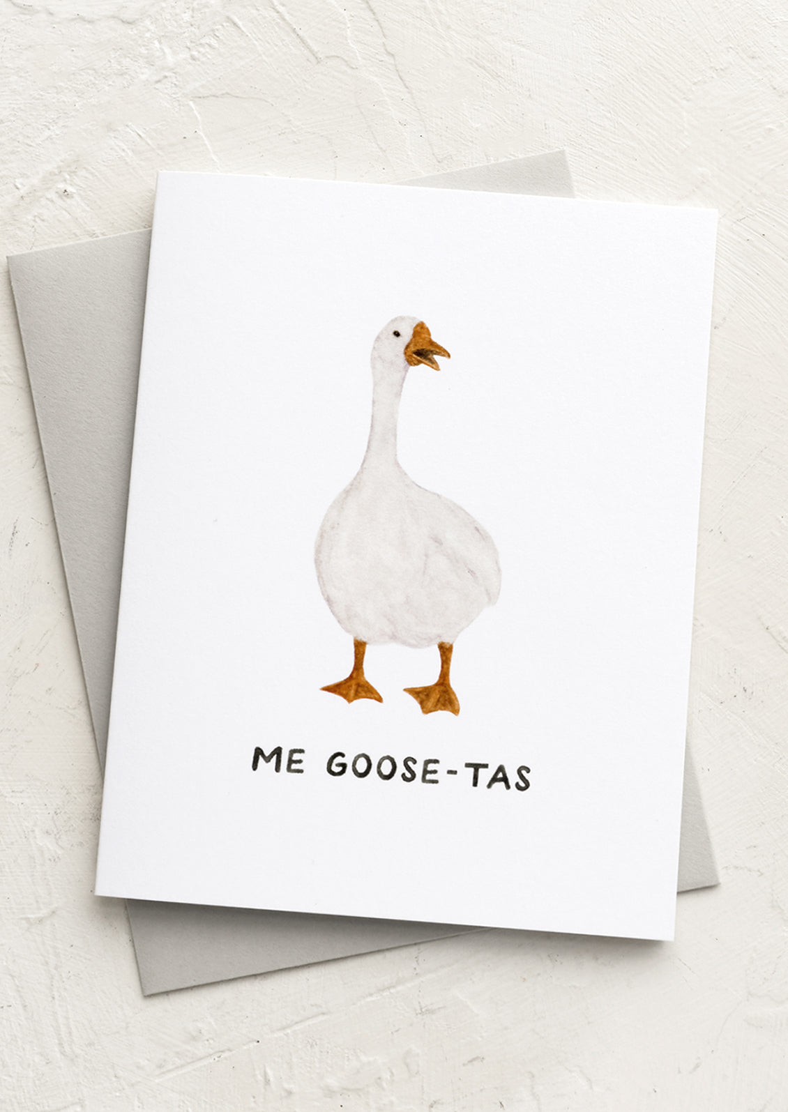A greeting card with image of goose and text reading "Me goose-tas".