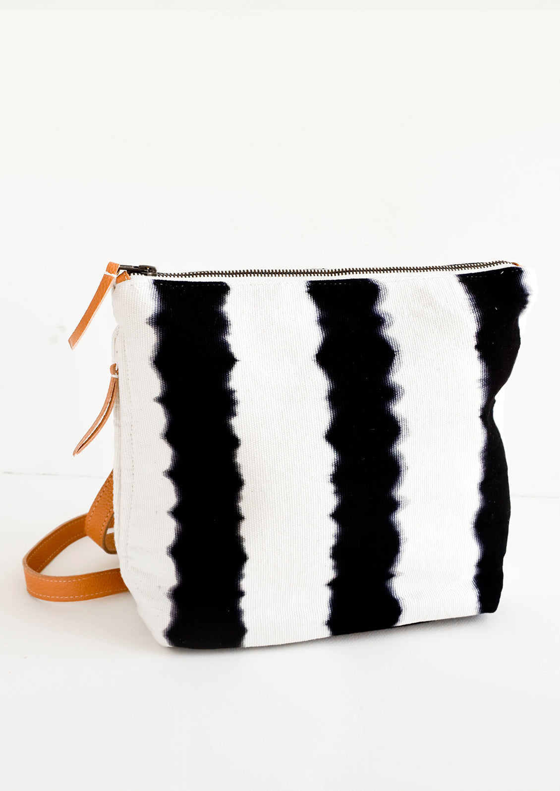 Fashion backpack made from cotton canvas in black & white tie dye stripes with tan leather accents
