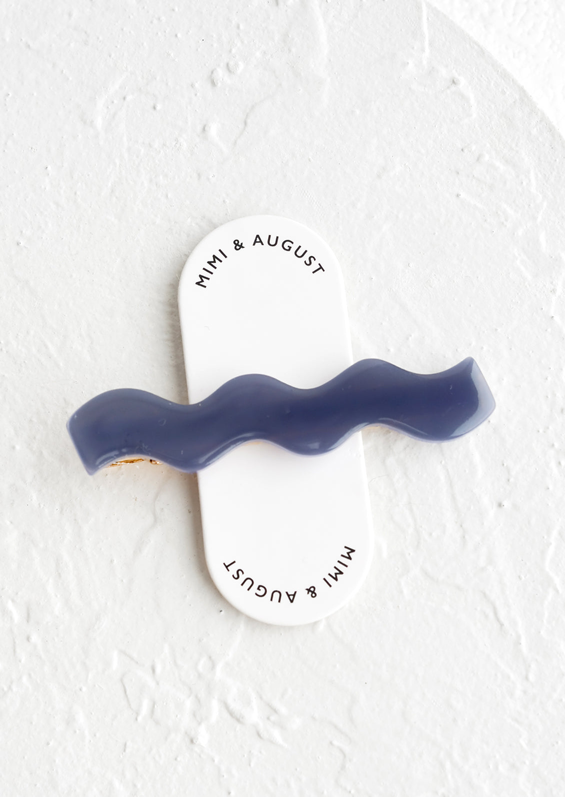 A blue acetate hair clip in rectangular shape with wavy curve shape.