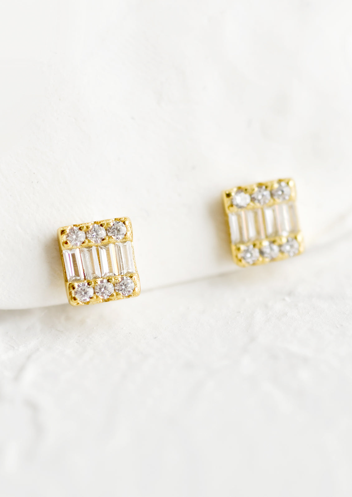 Square gold stud earrings with art deco look and sparkling cubic zirconia.