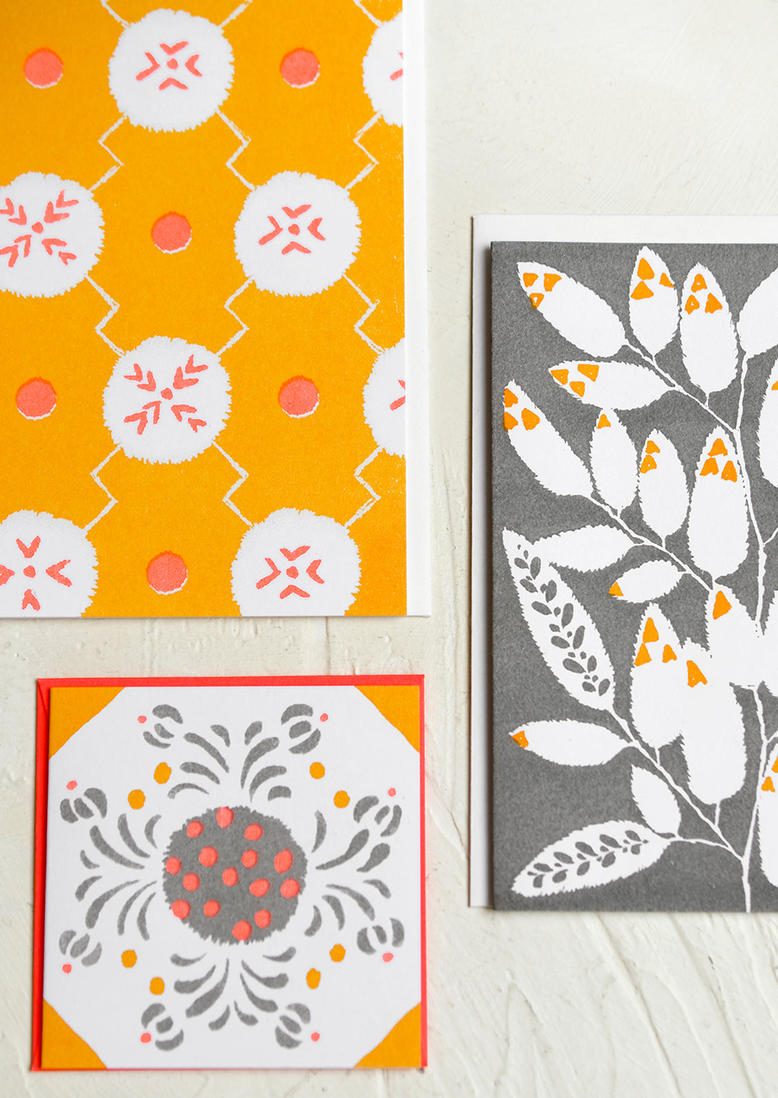A patterned risograph printed card set in grey, coral and orange.