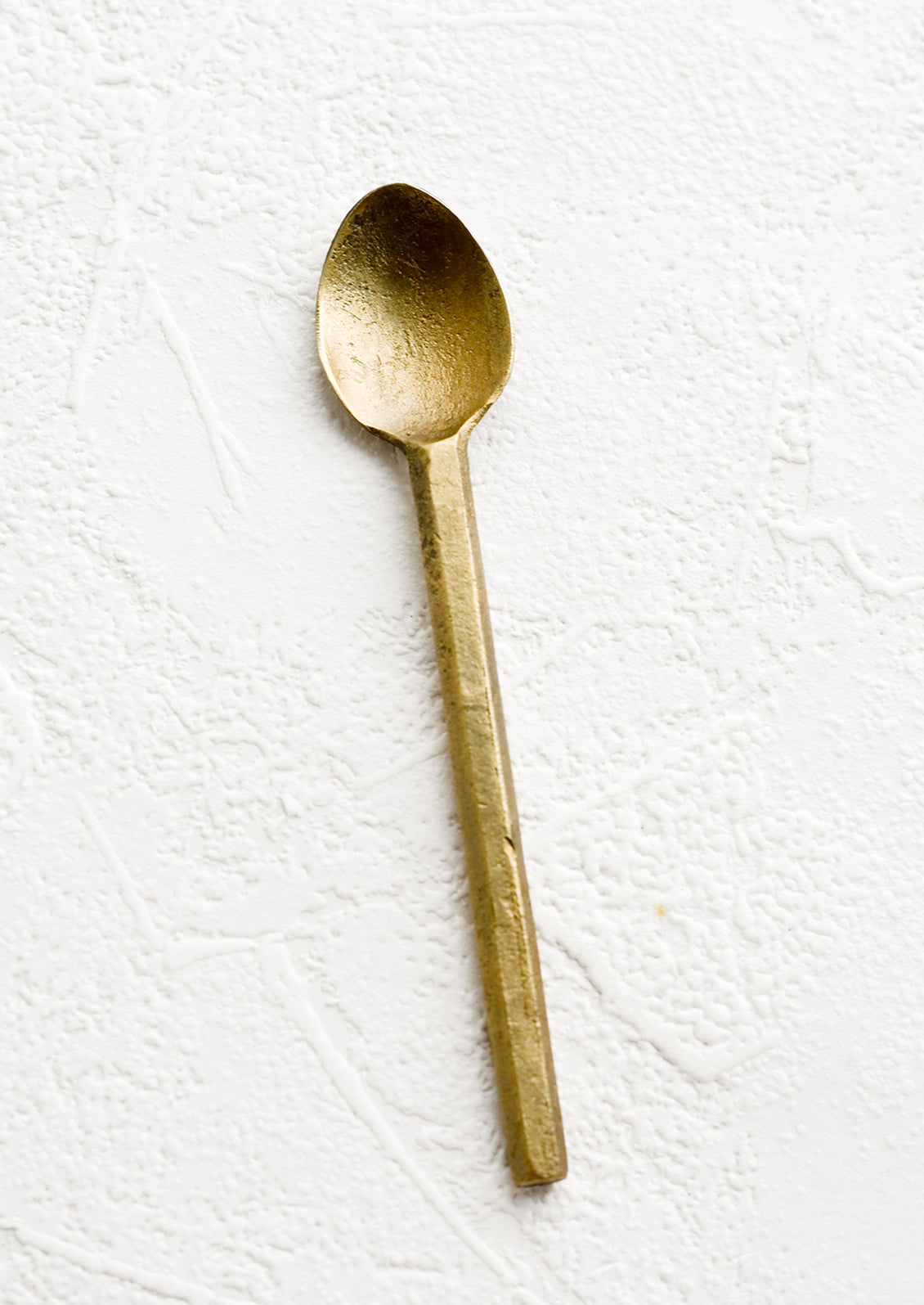 A small canape spoon in matte textured brass.