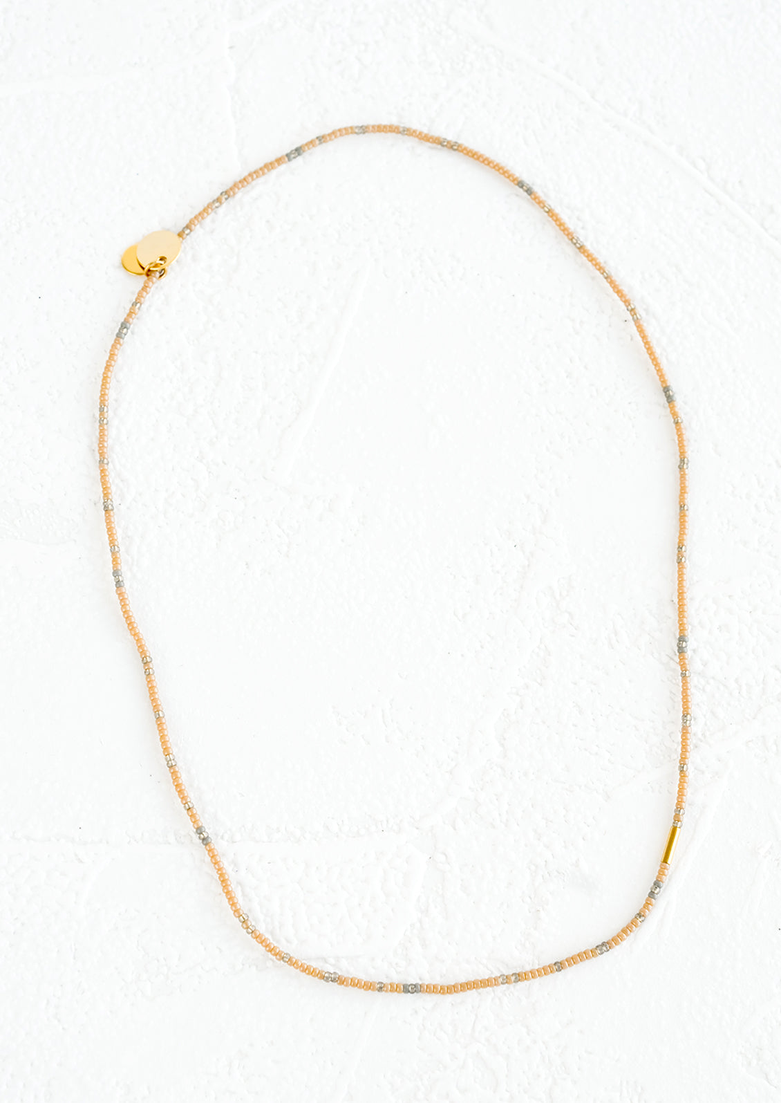 A seed bead choker necklace in tan and grey beads..