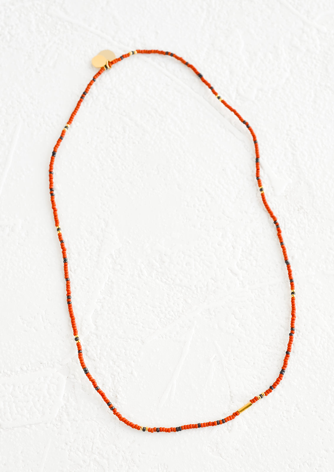 A seed bead choker necklace in rust and charcoal.