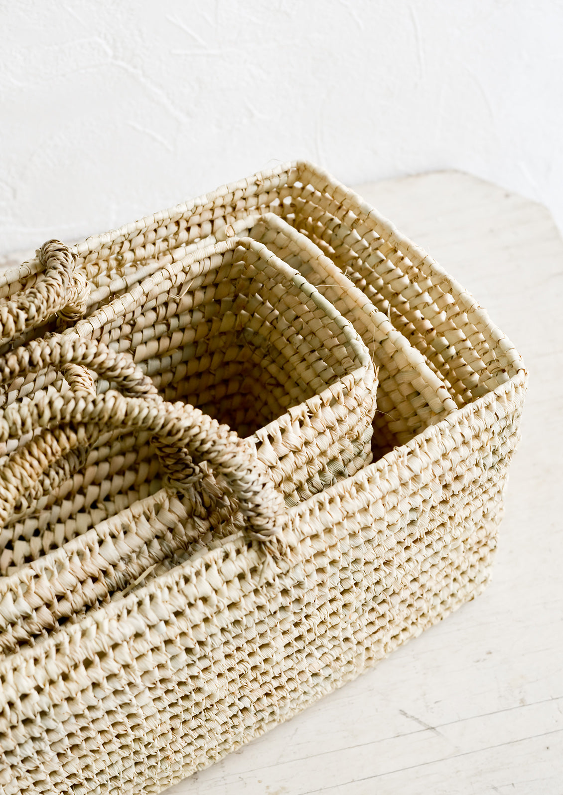 Palm leaf baskets in narrow, rectangular shape, nested together.