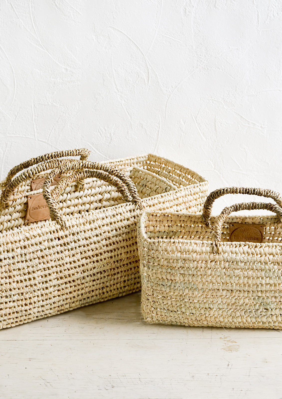 Palm leaf storage baskets with handles in slim, squared shape; three sizes that nest together.