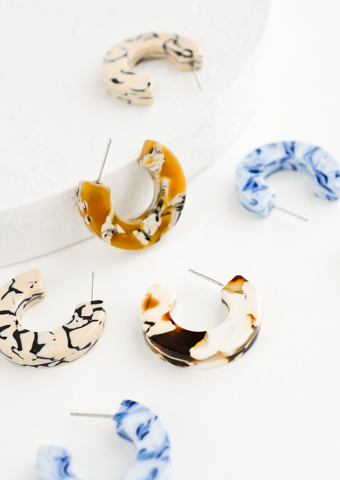Scattered acetate hoop earrings in assorted colors.