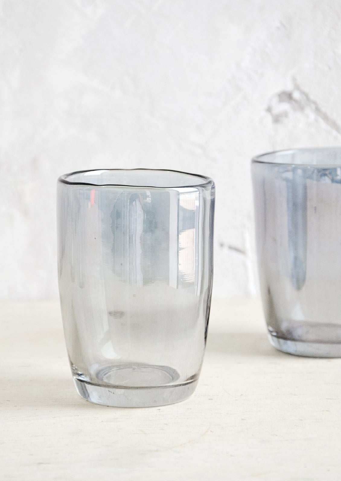 Clear glass tumblers with grey tint and subtle metallic finish