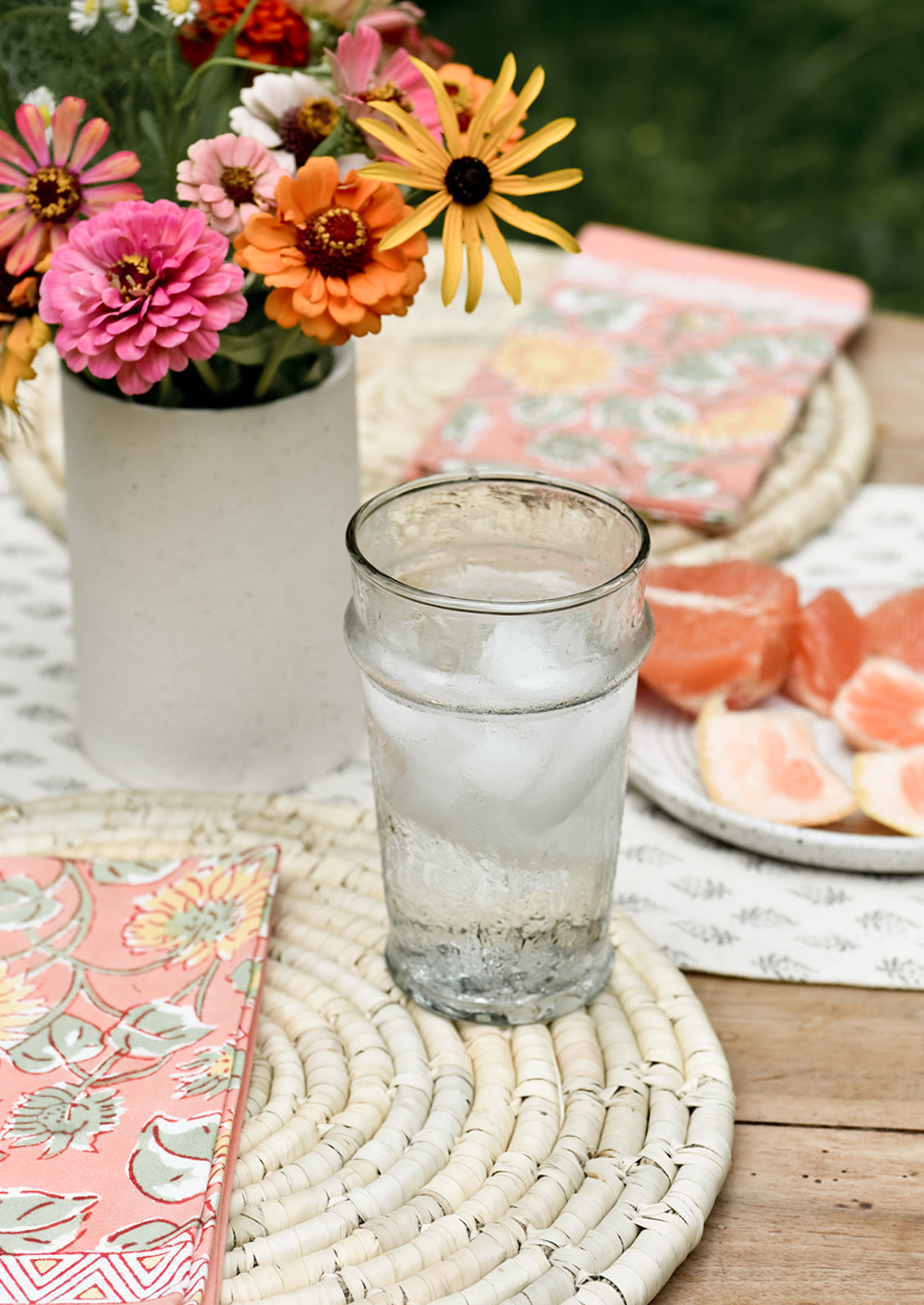 A table setting with placemats, napkins and water glass.