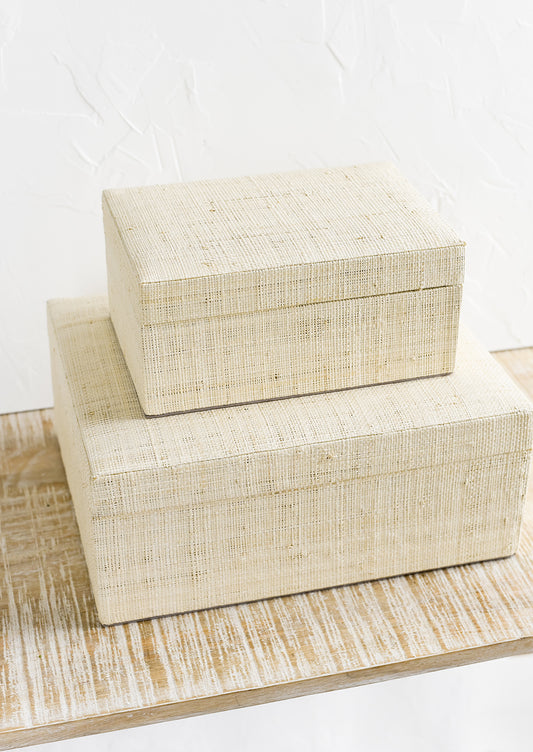 Small and large upholstered linen storage boxes.
