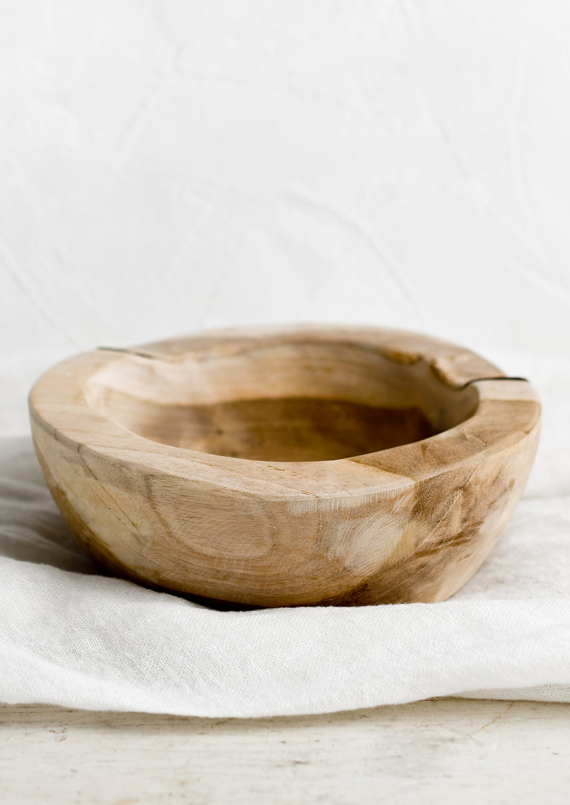 A teakwood bowl with natural cracks and cutout.