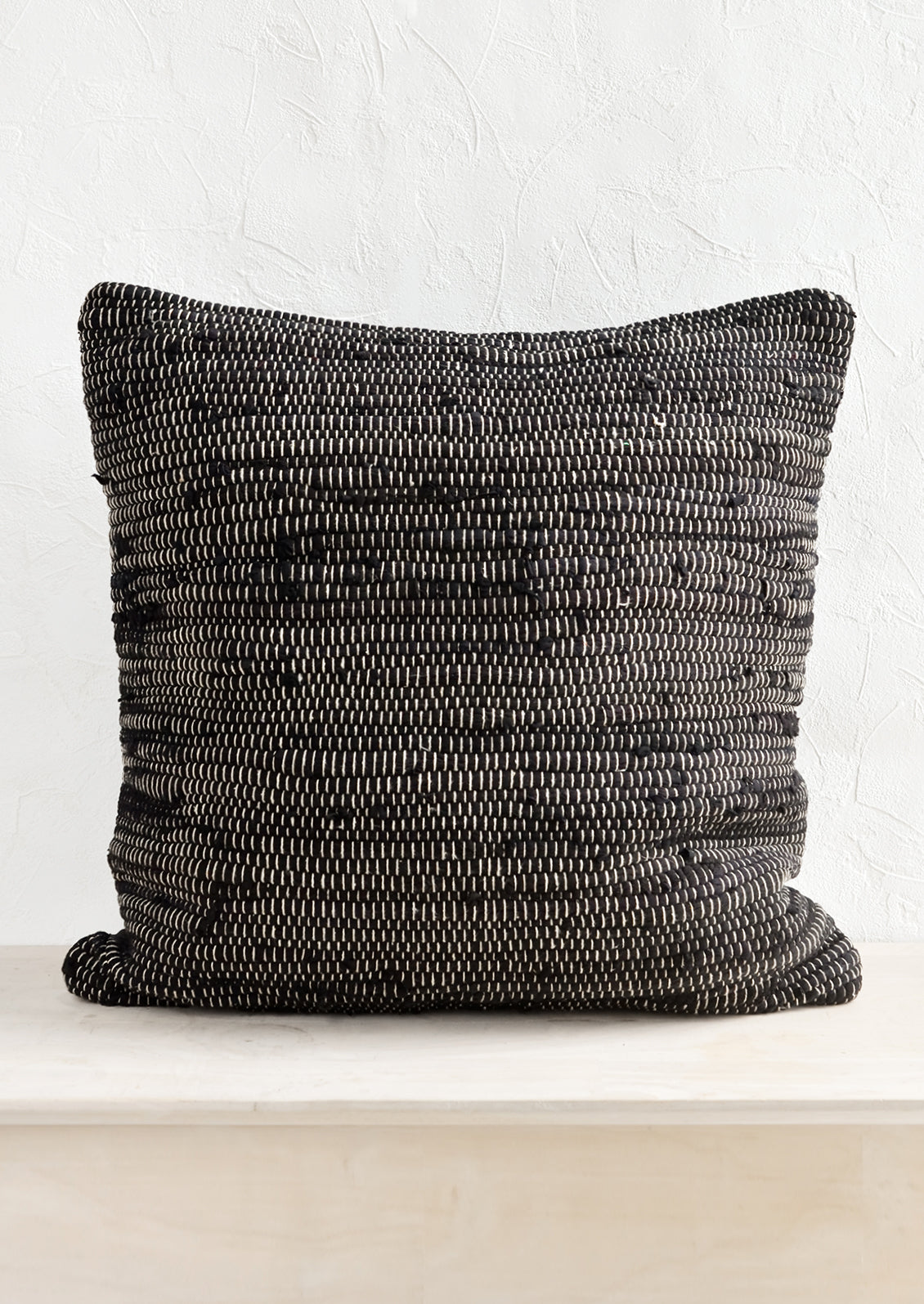 A black and white chindi weave throw pillow.