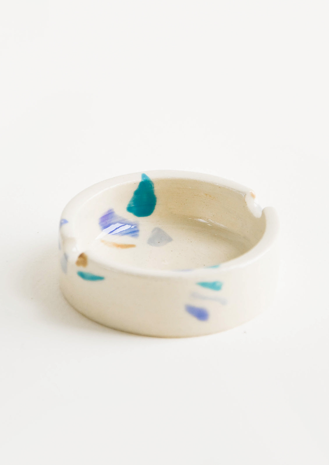 Ceramic ashtray with allover hand painted terrazzo pattern in a variety of cool colors