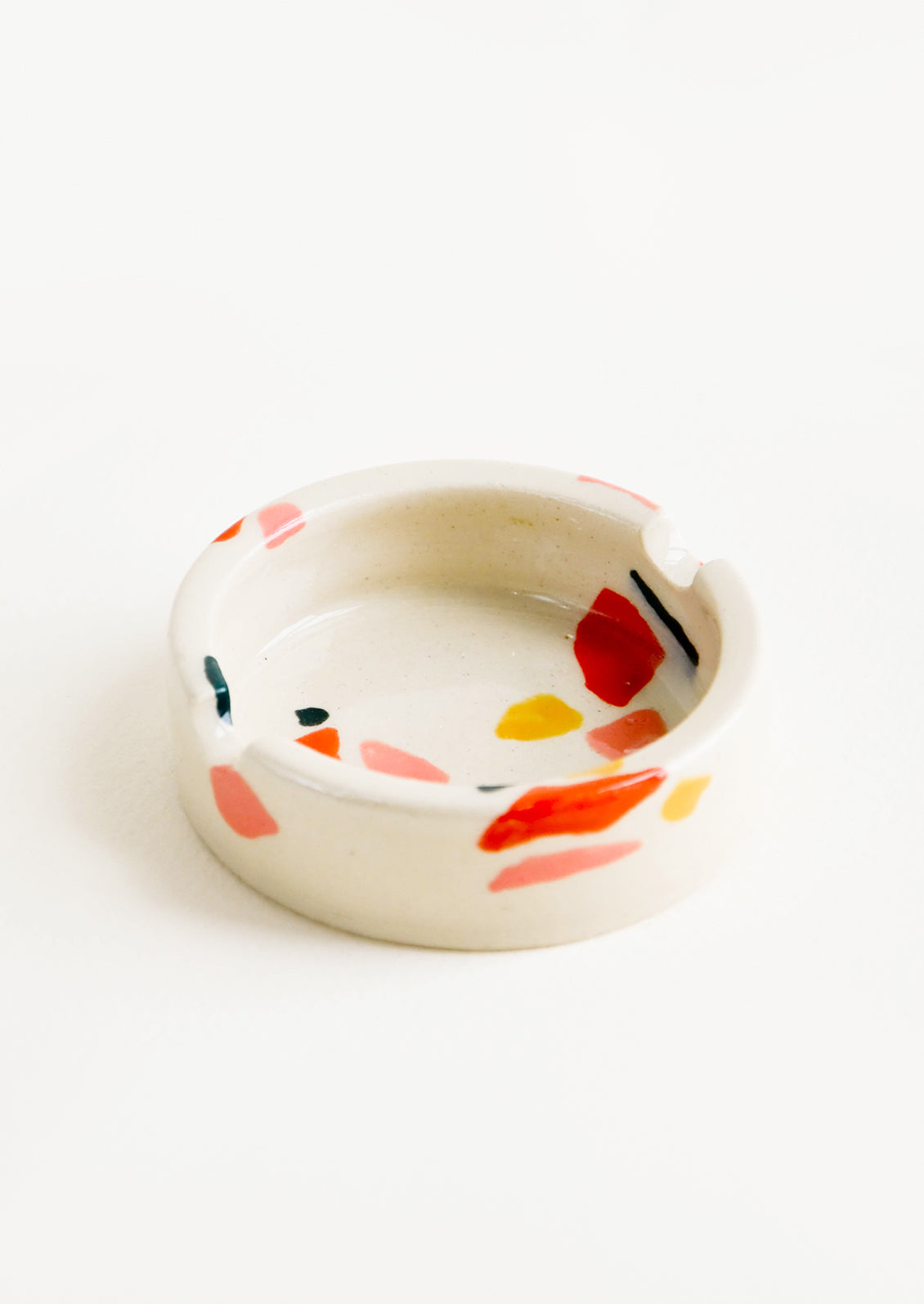 Ceramic ashtray with allover hand painted terrazzo pattern in a variety of warm colors