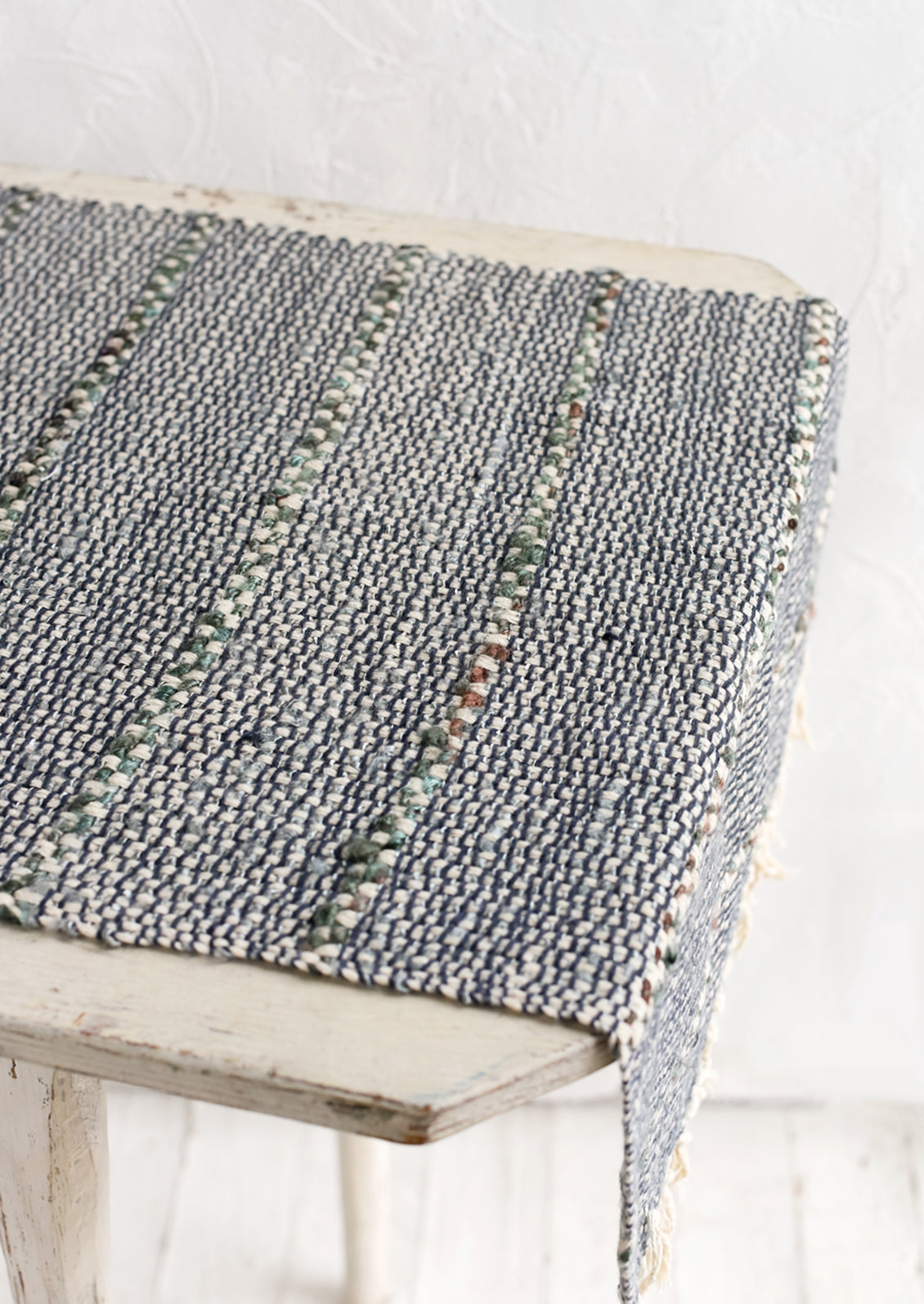 A blue and green table runner with stripe detail.