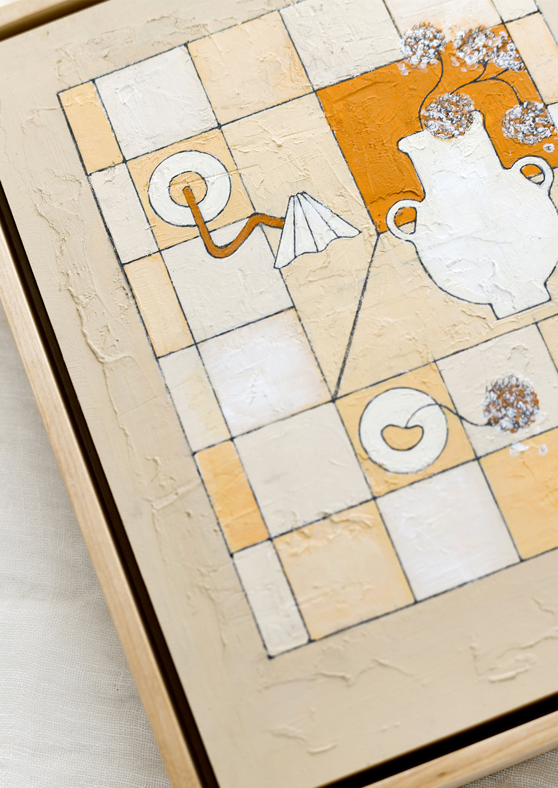 A framed original painting of gridded still life scene in white, tan and rust.
