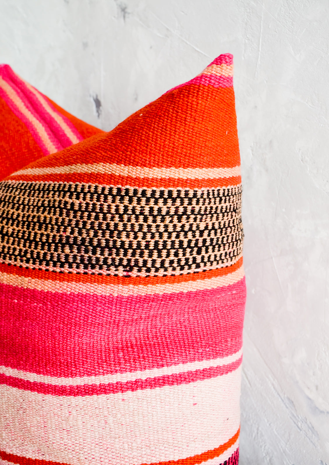 Throw pillow made from vintage striped wool in vibrant pink, orange and peach