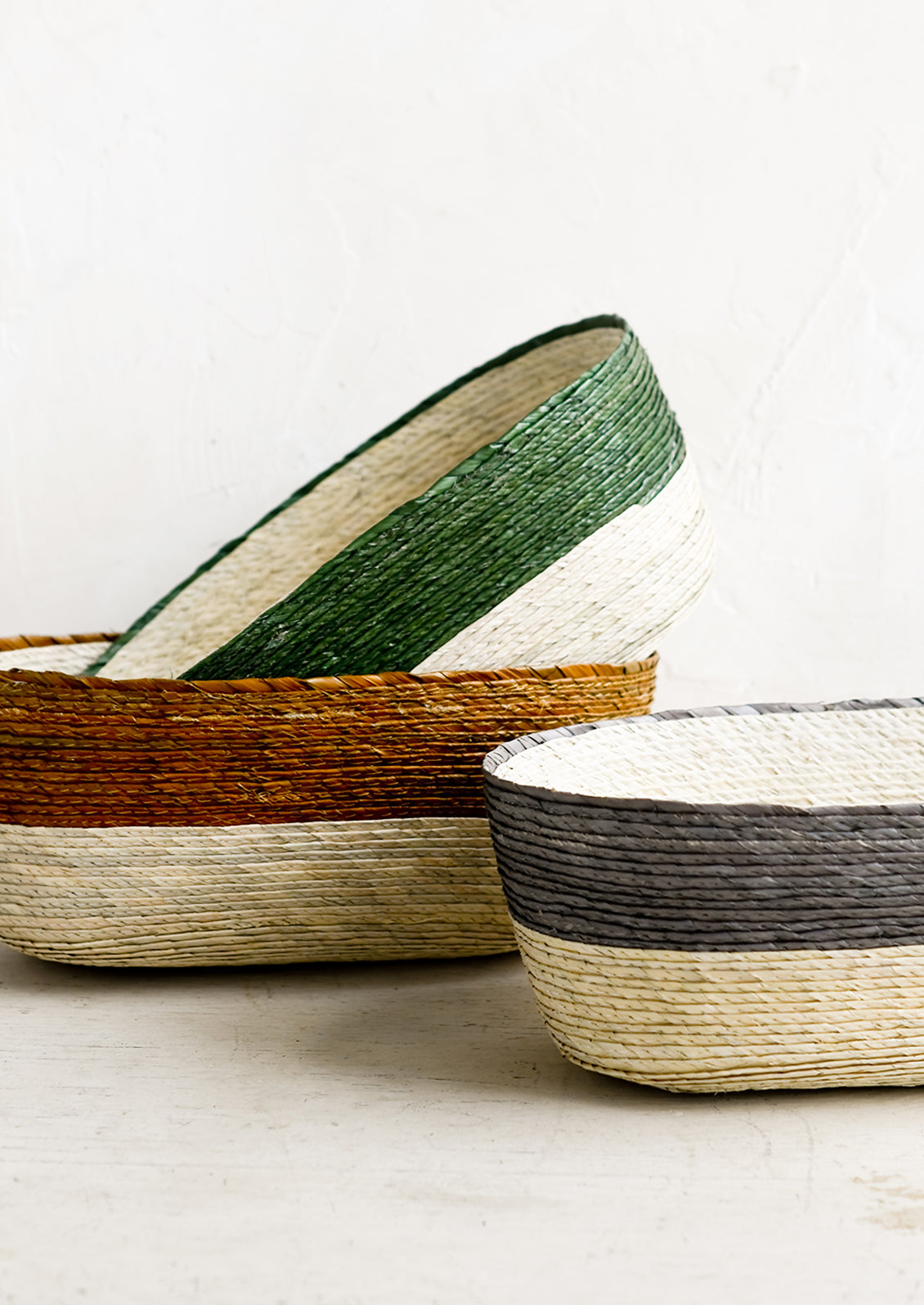Oval shaped straw storage baskets in assorted colors.