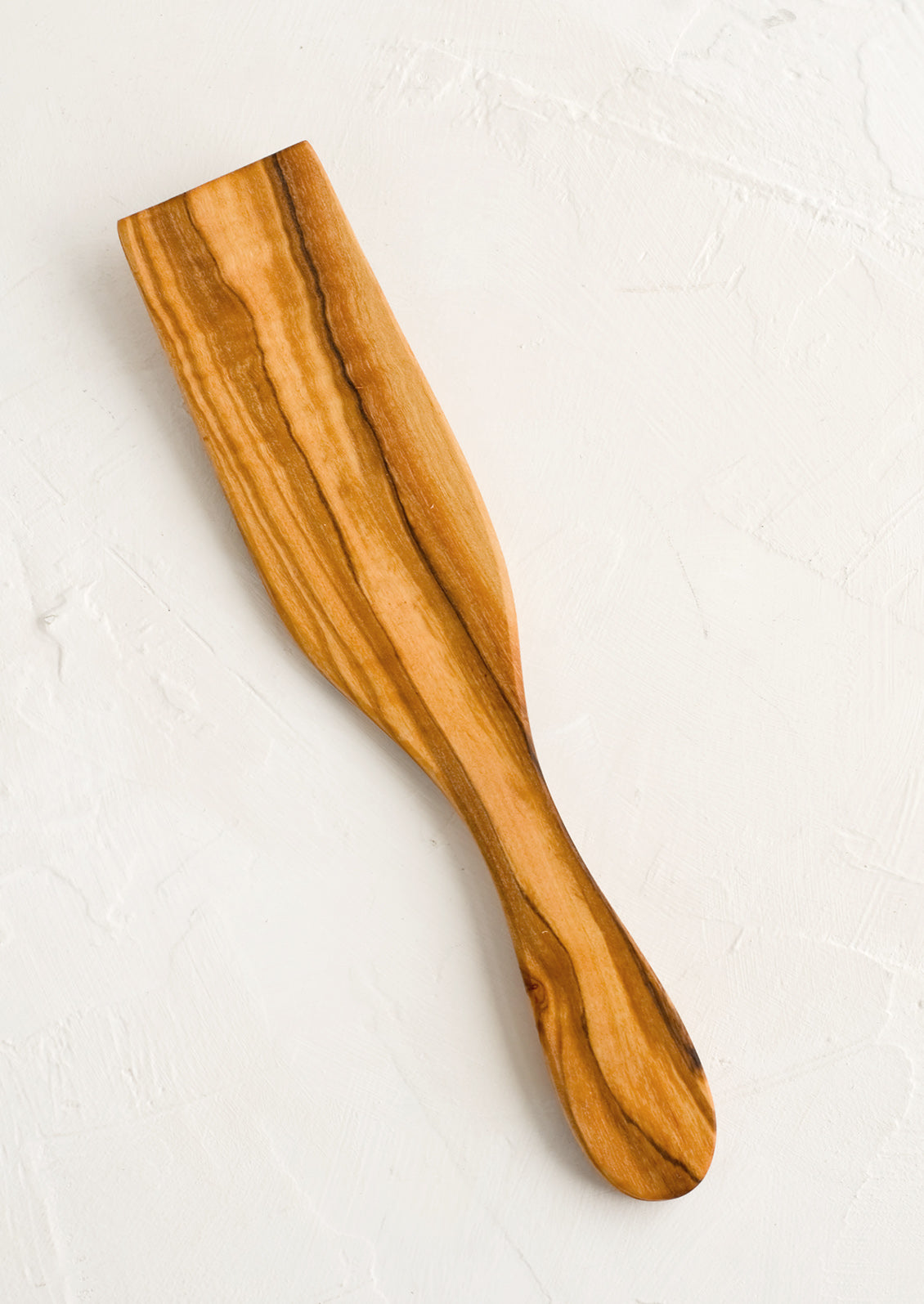 A wooden serving utensil in flat spatula shape meant for serving pastries.