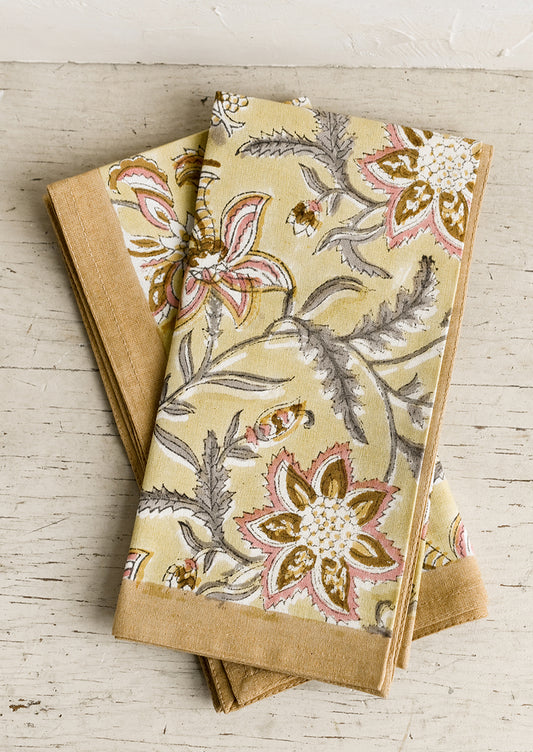 A pair of yellow floral paisley print napkins.