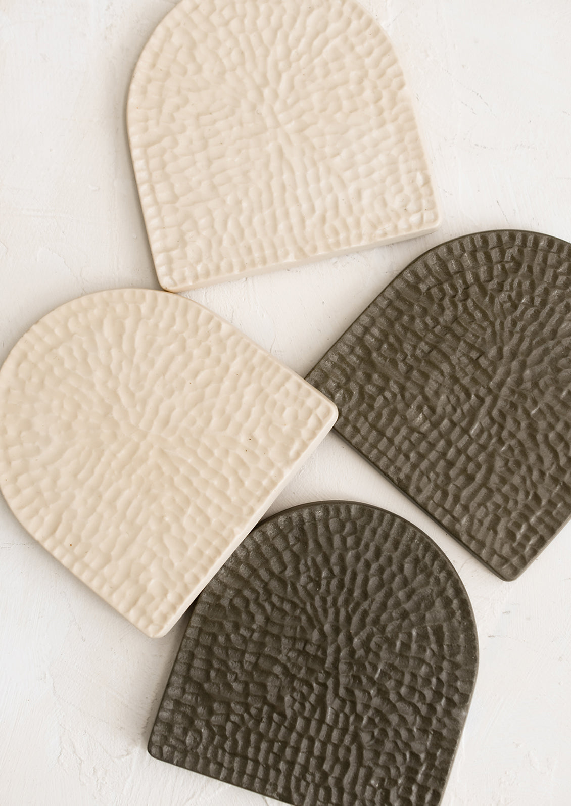 Textured, arch-shaped coasters in two colors.