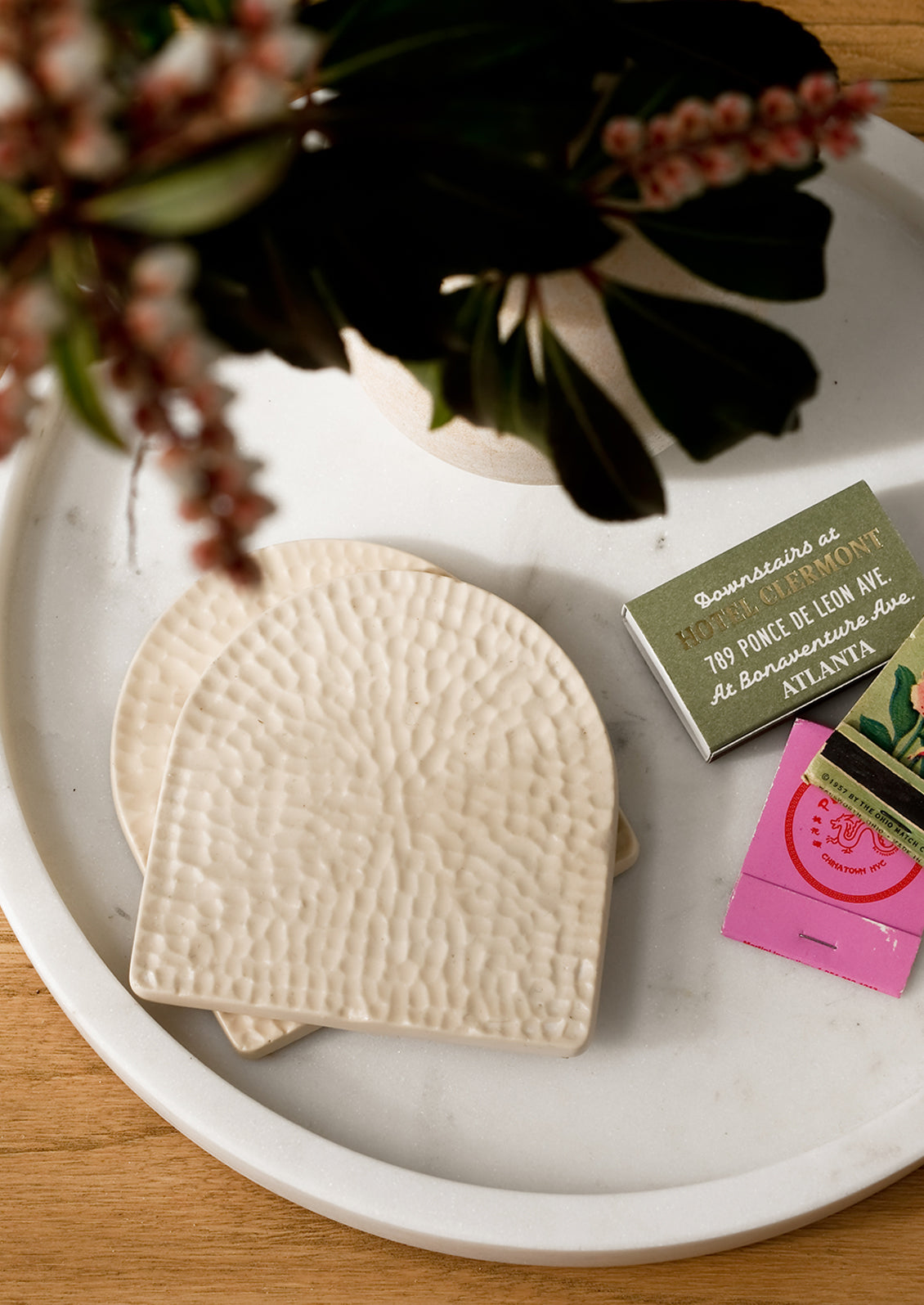 Cream coasters on a tray with matches.