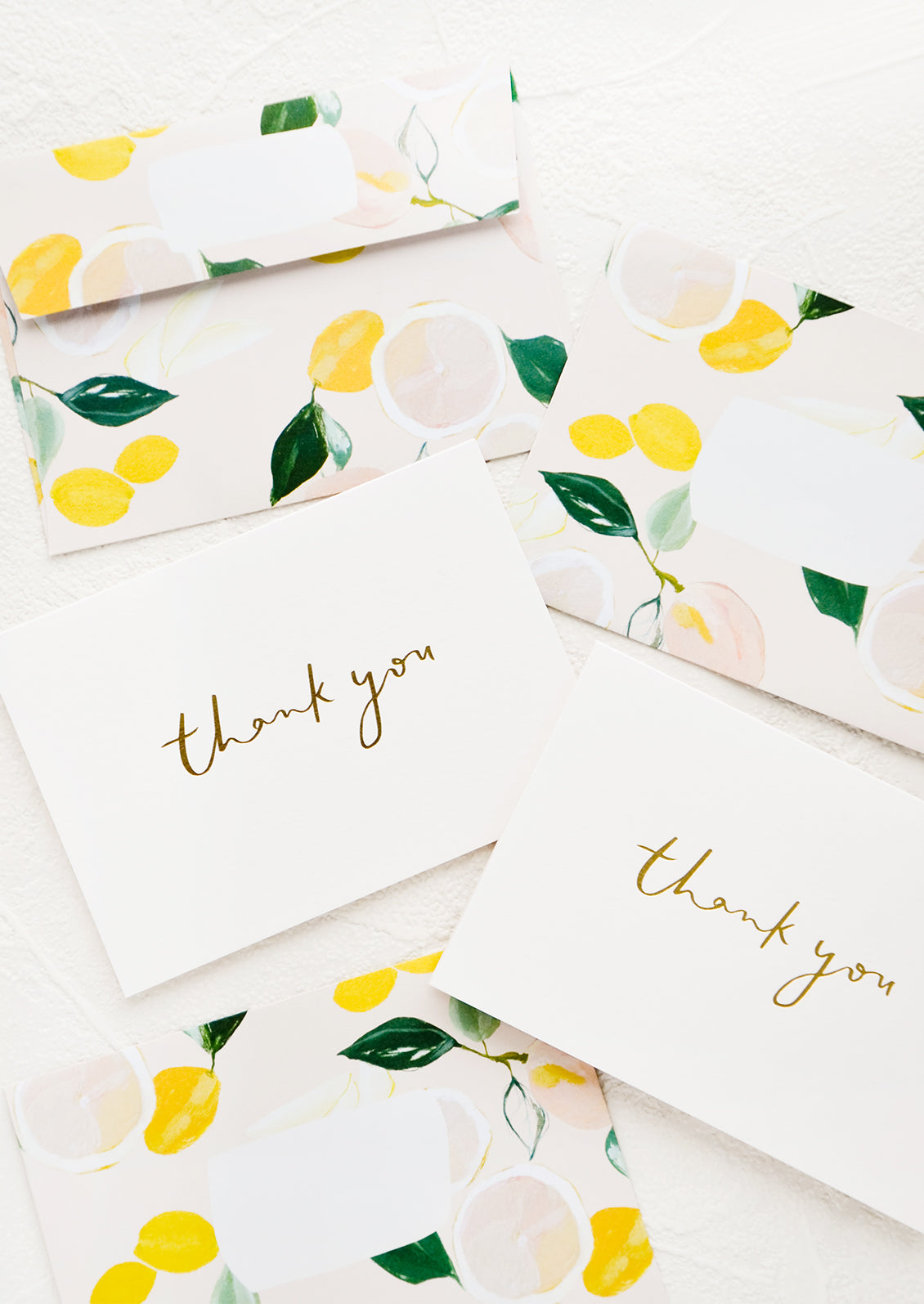 White greeting cards with gold "Thank You" text and citrus patterned envelopes