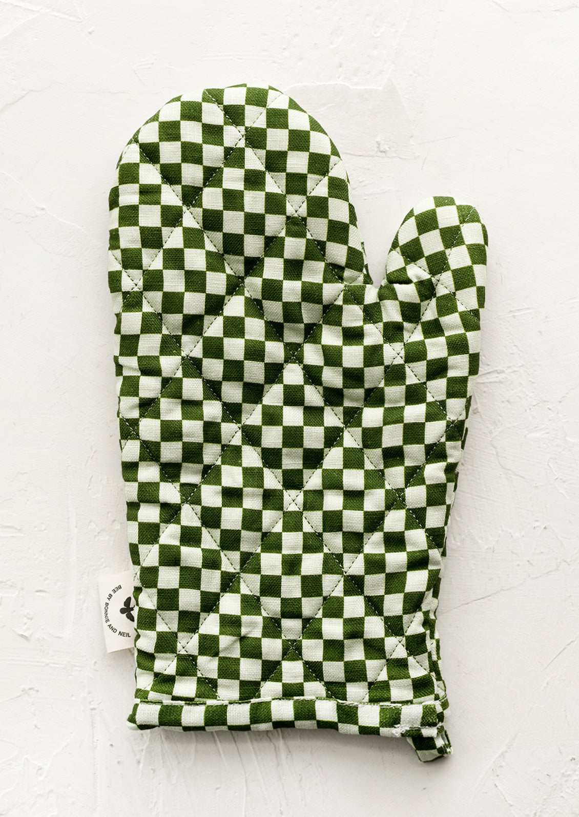 A quilted oven mitt in two tone green checker print.