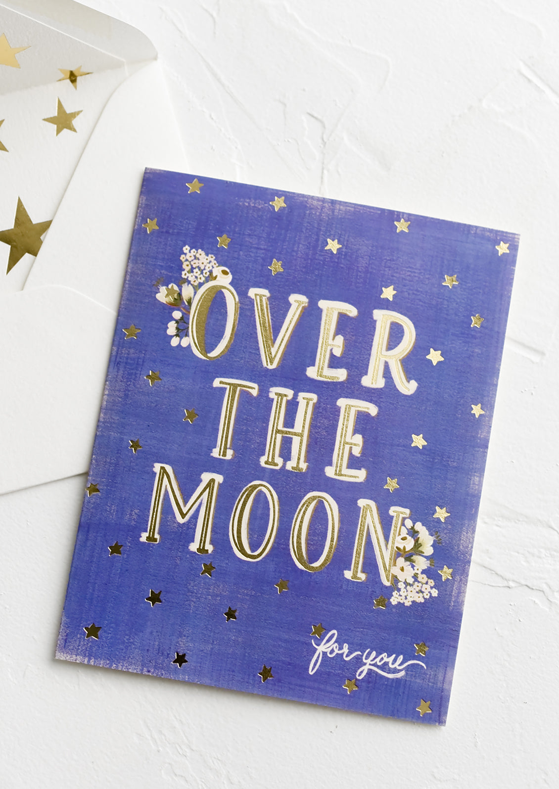 A greeting card with star print reading "Over the moon for you".