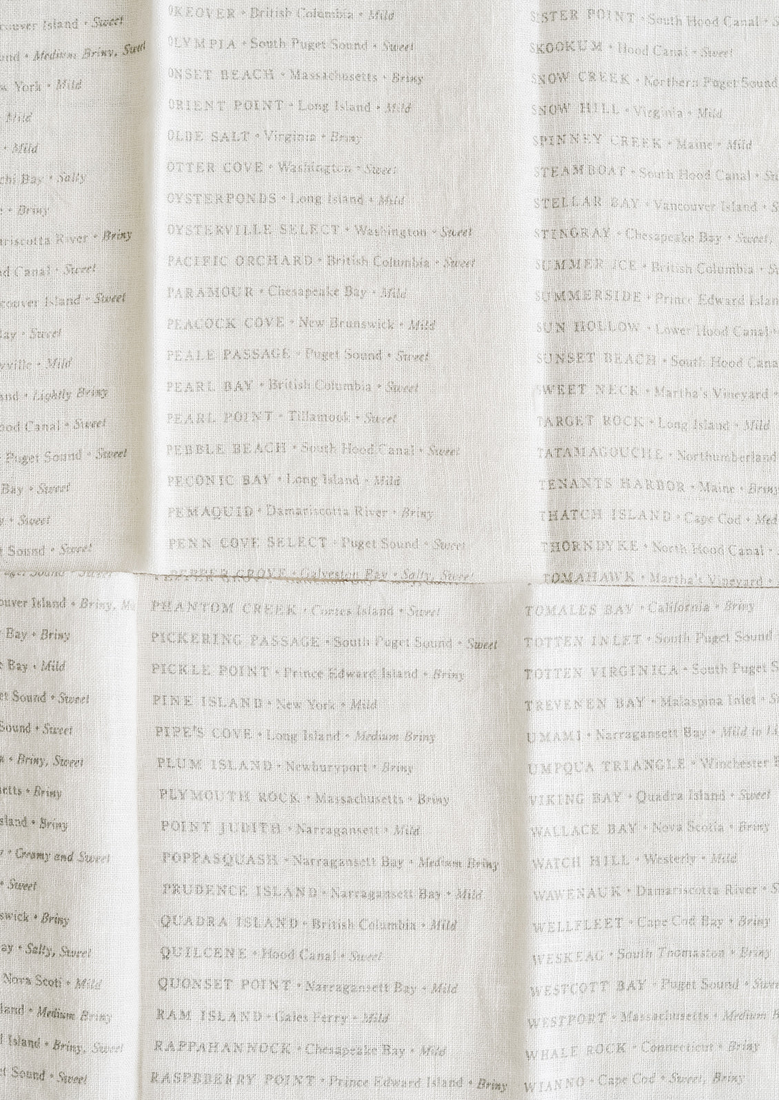 Grey serif text listing out oyster varieties on white linen.