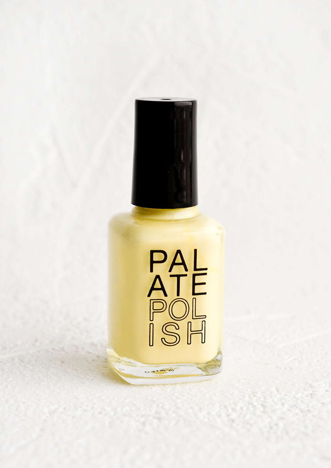 A bottle of nail polish in butter yellow.