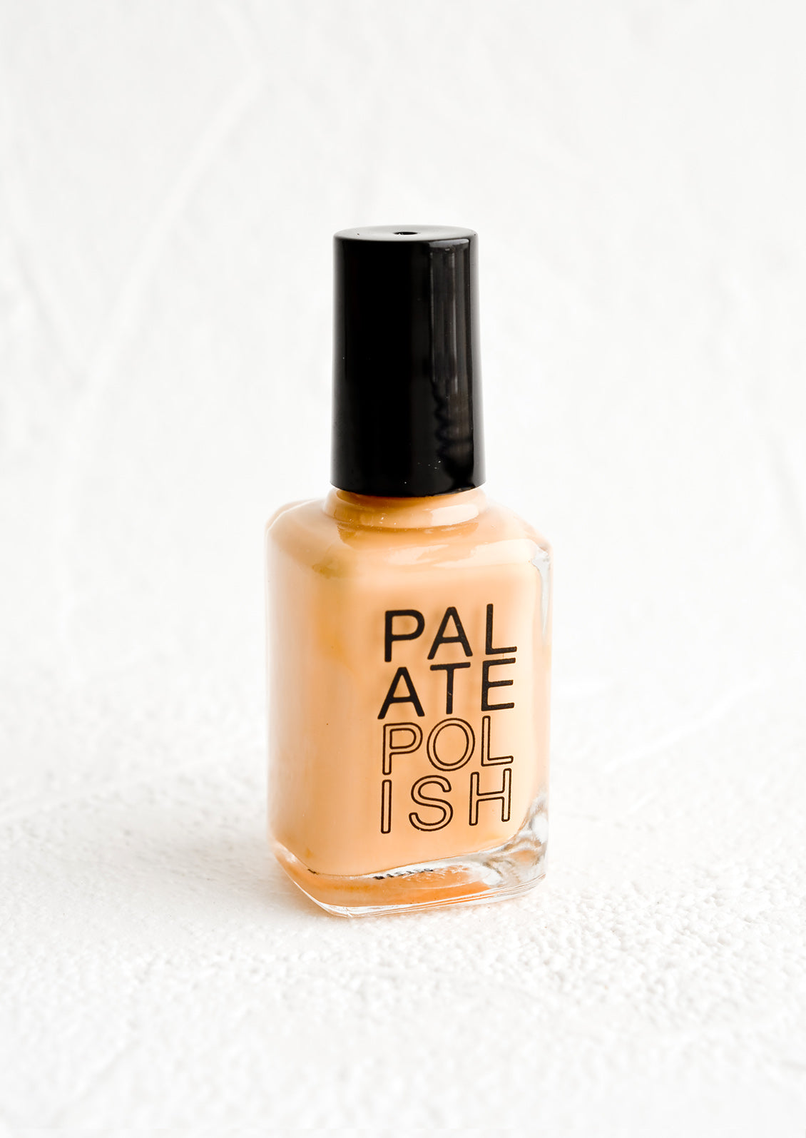 A bottle of nail polish in peach.