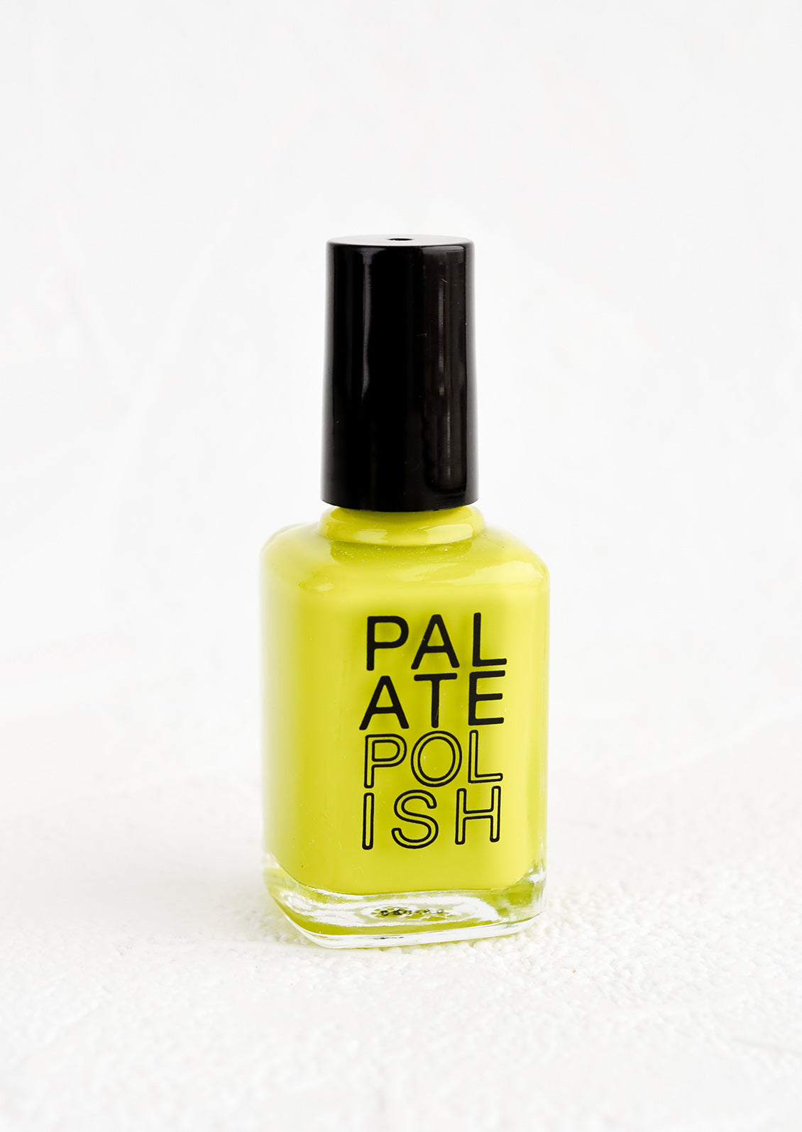 A bottle of nail polish in neon yellow-green.