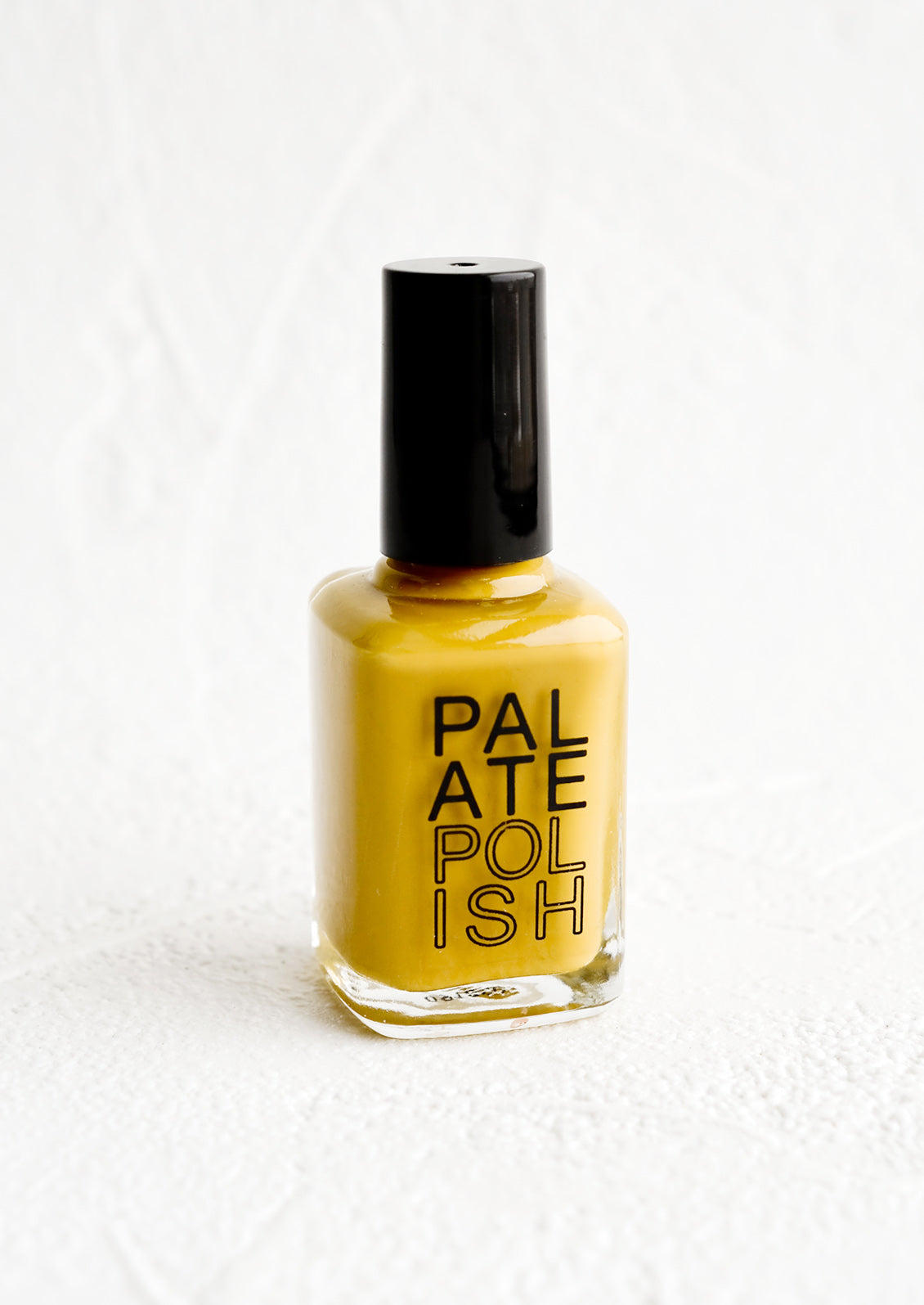 A bottle of nail polish in mustard.