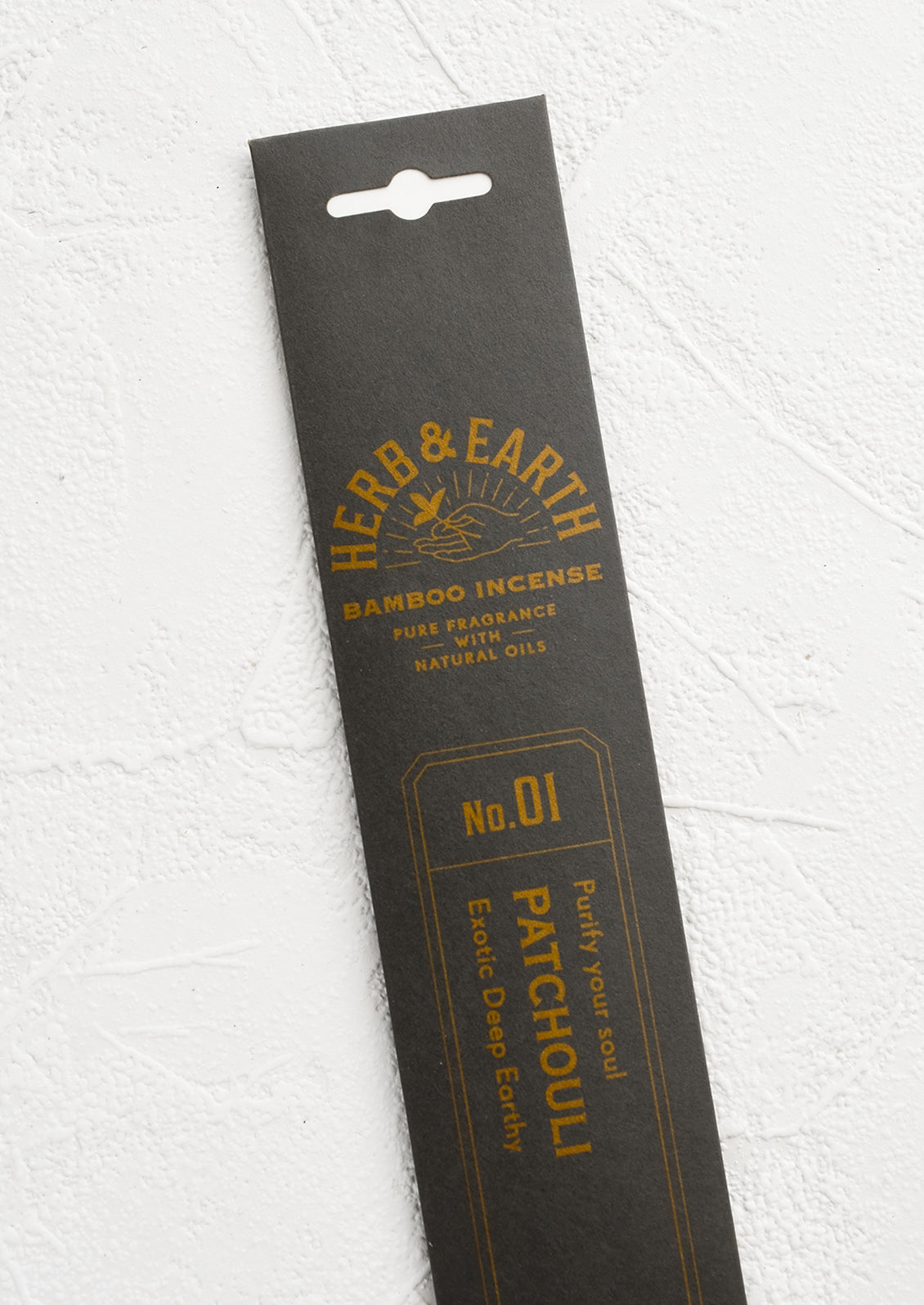 A dark grey packaging sleeve containing patchouli scented incense.