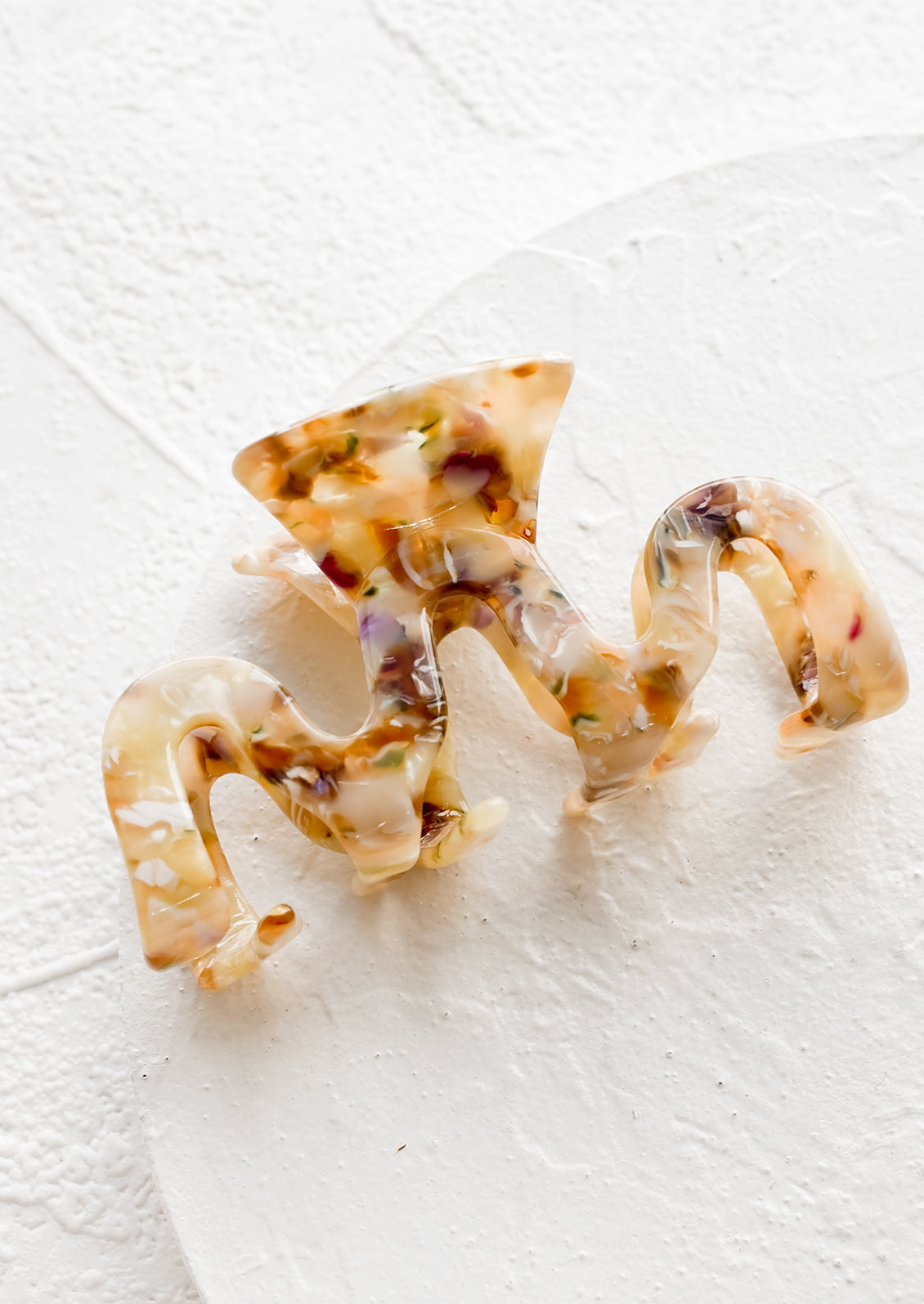 An acetate hair clip in squiggle shape in multicolor marble.