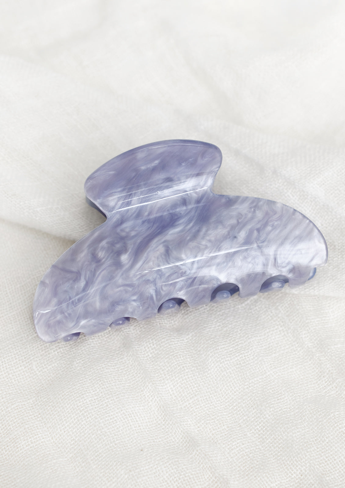 A plastic hair claw in pearlized periwinkle.
