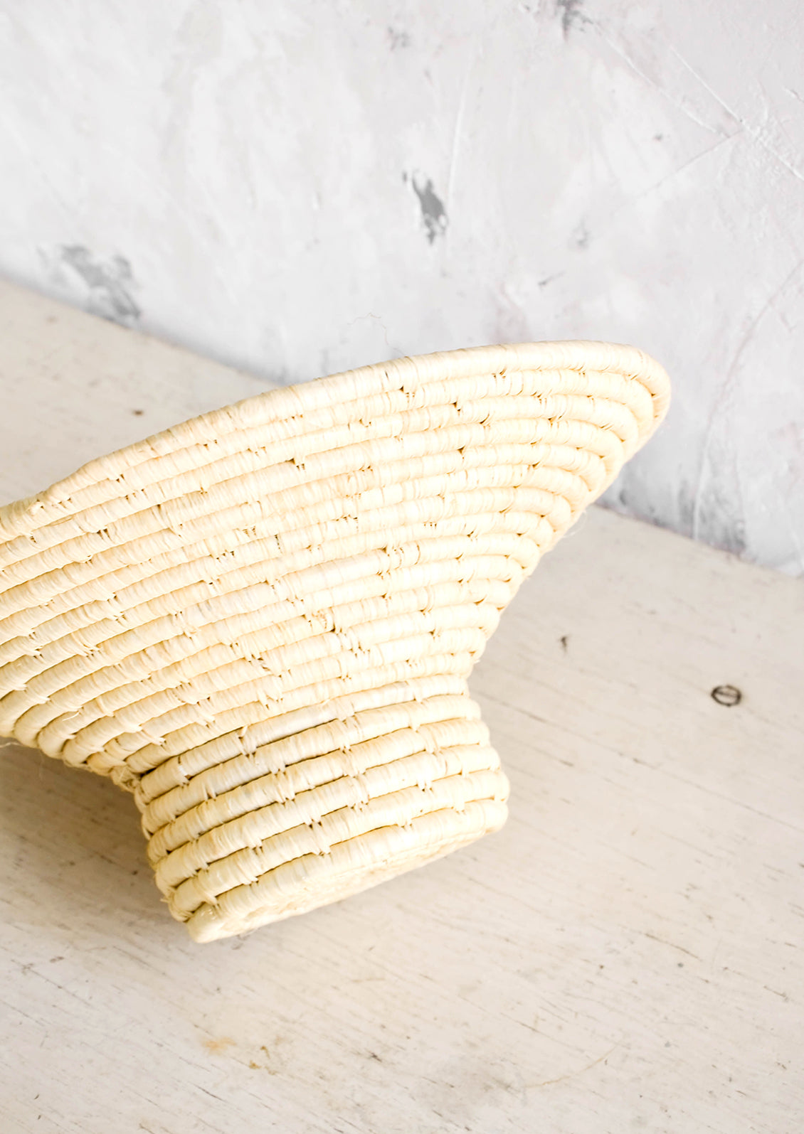 Woven raffia bowl with tapered top and round, footed base