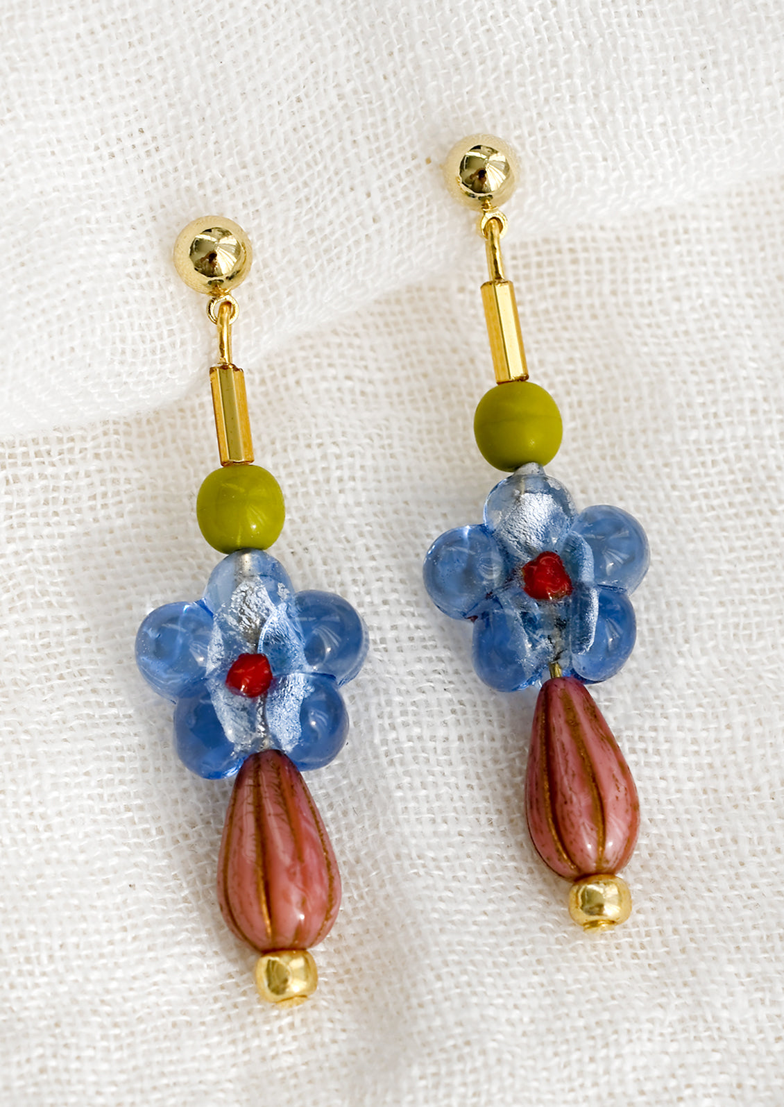 A pair of multi beaded drop earrings with blue glass flower bead at center.