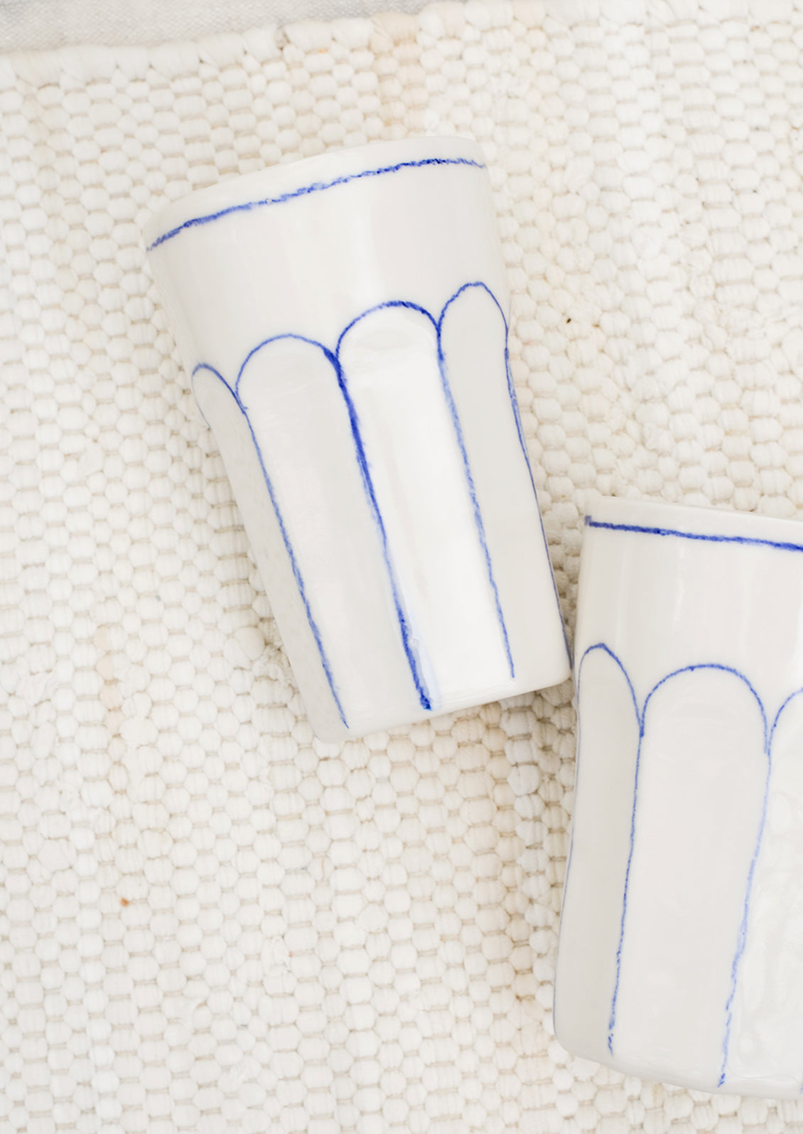 Two ivory ceramic tumblers.